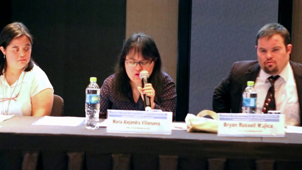 María Alejandra Villanueva speaks into a microphone during the first gathering of self-advocates organised by the Peruvian Down Syndrome Society, seated beside Karin Liza and Bryan Russell Mujica.